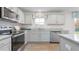 Modern kitchen featuring stainless steel appliances, light grey cabinets, white countertops and a large window at 487 Lochalsh Dr, Gibsonville, NC 27249