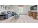 Cozy living room features a comfortable blue sectional sofa, stylish ottoman, and sleek entertainment center at 487 Lochalsh Dr, Gibsonville, NC 27249