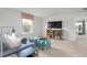 Bright living room with large window, modern shelving unit, and stylish blue sectional sofa and ottomans at 487 Lochalsh Dr, Gibsonville, NC 27249