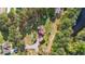 Aerial view showcasing a home with a separate garage, surrounded by lush greenery and mature trees at 50 Gill Ln, Fuquay Varina, NC 27526