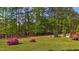 Spacious backyard with mature trees, green grass, and lake views at 50 Gill Ln, Fuquay Varina, NC 27526