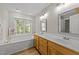 Bathroom featuring double sink, a large window with a soaking tub, and wood-look floors at 50 Gill Ln, Fuquay Varina, NC 27526