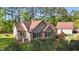 Charming tan home featuring a brick chimney, mature landscaping, and an accessory building at 50 Gill Ln, Fuquay Varina, NC 27526