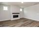 Minimalist living room with modern fireplace, wood-look floors, and bright natural light at 528 Folk Song Way, Wendell, NC 27591