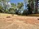 Large, empty backyard with a new wooden fence and mature trees at 5504 Kingwood Dr, Raleigh, NC 27609