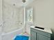 Bathroom with marble tile, white tub, and blue vanity at 5504 Kingwood Dr, Raleigh, NC 27609