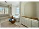 Bright bathroom features a modern soaking tub beneath a window and dual vanity at 5504 Kingwood Dr, Raleigh, NC 27609