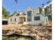 Gorgeous new construction home boasts a white brick, chimney, black framed windows, and green trees at 5504 Kingwood Dr, Raleigh, NC 27609