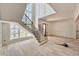 Elegant foyer with a curved staircase, glass block windows, and unfinished hardwood floors at 5504 Kingwood Dr, Raleigh, NC 27609