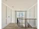 Bright hallway features white walls, a curved railing, and a large window for natural light at 5504 Kingwood Dr, Raleigh, NC 27609