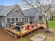 Spacious wood deck is equipped with grilling area, lounge furniture and string lights at 555 Canterwood Dr, Mebane, NC 27302