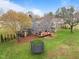 Aerial view of the home's backyard with deck, play set and manicured lawn at 555 Canterwood Dr, Mebane, NC 27302