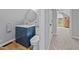 Bathroom with blue vanity, granite countertop, a mirror, and toilet at 555 Canterwood Dr, Mebane, NC 27302