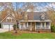 Charming home featuring a covered front porch, gray siding and dormer windows at 555 Canterwood Dr, Mebane, NC 27302