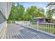 Wooden back deck offers a serene outdoor space with a white railing, surrounded by trees and nature at 612 E Academy St, Fuquay Varina, NC 27526
