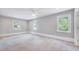 Spacious bedroom with neutral walls and carpet, offering ample natural light through three windows at 612 E Academy St, Fuquay Varina, NC 27526