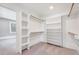 Well-organized walk-in closet with custom shelving and clothing racks, carpeted floor, and bright natural light at 612 E Academy St, Fuquay Varina, NC 27526