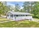 Ranch home featuring a large back deck, gray painted brick, and beautiful lawn at 612 E Academy St, Fuquay Varina, NC 27526