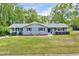 Charming ranch-style home featuring gray paint, blue shutters, and lush landscaping at 612 E Academy St, Fuquay Varina, NC 27526