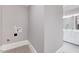 Minimalist laundry area next to a bathroom with gray walls and neutral tile at 612 E Academy St, Fuquay Varina, NC 27526