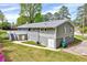 Rear view of a gray ranch-style house featuring a large deck and lush green lawn at 612 E Academy St, Fuquay Varina, NC 27526