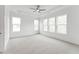 A bright bedroom features tray ceilings, a ceiling fan, and several windows bringing in natural light at 616 Gainer Dr # 15, Raleigh, NC 27610