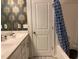 Bathroom with wallpaper, double vanity, and a shower with curtain at 6332 Andante Ave, Raleigh, NC 27616