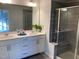 Bathroom featuring a double vanity with white cabinets, large mirror, and glass-enclosed tiled shower at 6332 Andante Ave, Raleigh, NC 27616