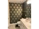 Quaint bathroom with patterned wallpaper, toilet, and sink with vanity, creating a unique and cozy space at 6332 Andante Ave, Raleigh, NC 27616