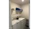 Bright laundry room with white washer and dryer and a wire shelf for storage at 6332 Andante Ave, Raleigh, NC 27616