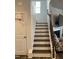 Stairway with wooden banister and door featuring mini basketball hoop at 6332 Andante Ave, Raleigh, NC 27616