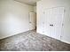 This bedroom features neutral paint, carpet floors, and a double-door closet at 68 S Grace Way, Henderson, NC 27537