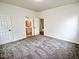 This bedroom features neutral paint, carpet floors, and a view of the attached bathroom at 68 S Grace Way, Henderson, NC 27537
