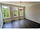 Bright dining room with large windows, chandelier, and wood floors; great natural light and a view at 687 Bandon Aly, Cary, NC 27513