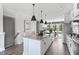 Spacious kitchen featuring a large island with bar seating, stainless steel appliances, and sleek pendant lighting at 687 Bandon Aly, Cary, NC 27513