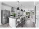 Bright kitchen boasts stainless steel appliances, a large center island with bar seating, and modern white cabinetry at 687 Bandon Aly, Cary, NC 27513