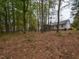 Large backyard with a wooded area and patio leading to the white home at 706 Mossburn Ct, Fuquay Varina, NC 27526