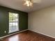 Bright bedroom boasts hardwood floors, a ceiling fan, and a large window at 706 Mossburn Ct, Fuquay Varina, NC 27526