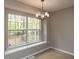 Bright dining area featuring a modern chandelier and a large window overlooking the backyard at 706 Mossburn Ct, Fuquay Varina, NC 27526