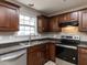 Traditional kitchen features stainless steel appliances, dark cabinets, and a tiled backsplash at 706 Mossburn Ct, Fuquay Varina, NC 27526