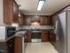Well-equipped kitchen with stainless steel appliances, dark cabinets, and tiled backsplash at 706 Mossburn Ct, Fuquay Varina, NC 27526