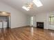 Bright living room featuring a fireplace, hardwood floors, and natural light from skylights and glass doors at 706 Mossburn Ct, Fuquay Varina, NC 27526