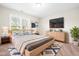 This primary bedroom features a large window, wall-mounted TV, and a queen-sized bed at 72 E Moss Creek Dr, Clayton, NC 27520