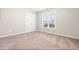 This empty carpeted room offers a window view, a closet, and neutral paint at 72 E Moss Creek Dr, Clayton, NC 27520