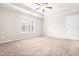 Main bedroom features neutral walls, plush carpet, and a tray ceiling with a ceiling fan at 72 E Moss Creek Dr, Clayton, NC 27520