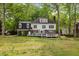 A view of the home's back exterior featuring a deck and a large, manicured backyard at 7709 Oakmont Pl, Raleigh, NC 27615