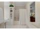 Bathroom with a tub-shower, shelving, and a glimpse of the living room at 7709 Oakmont Pl, Raleigh, NC 27615