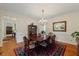 Traditional dining room with a chandelier, hardwood floors, and a formal dining set at 7709 Oakmont Pl, Raleigh, NC 27615