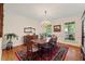 Classic dining room with hardwood floors, large window, chandelier, and formal wood furniture at 7709 Oakmont Pl, Raleigh, NC 27615