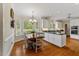 Sunlit dining area featuring hardwood floors, a bay window, and a modern chandelier at 7709 Oakmont Pl, Raleigh, NC 27615